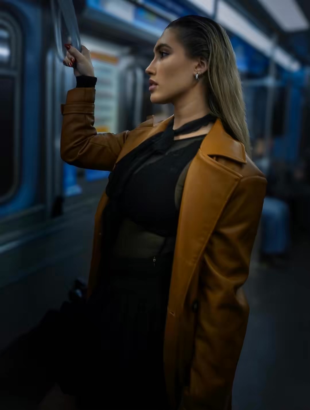 Woman in a brown coat inside a train